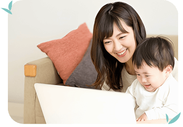子どもを抱っこして仕事をしている女性